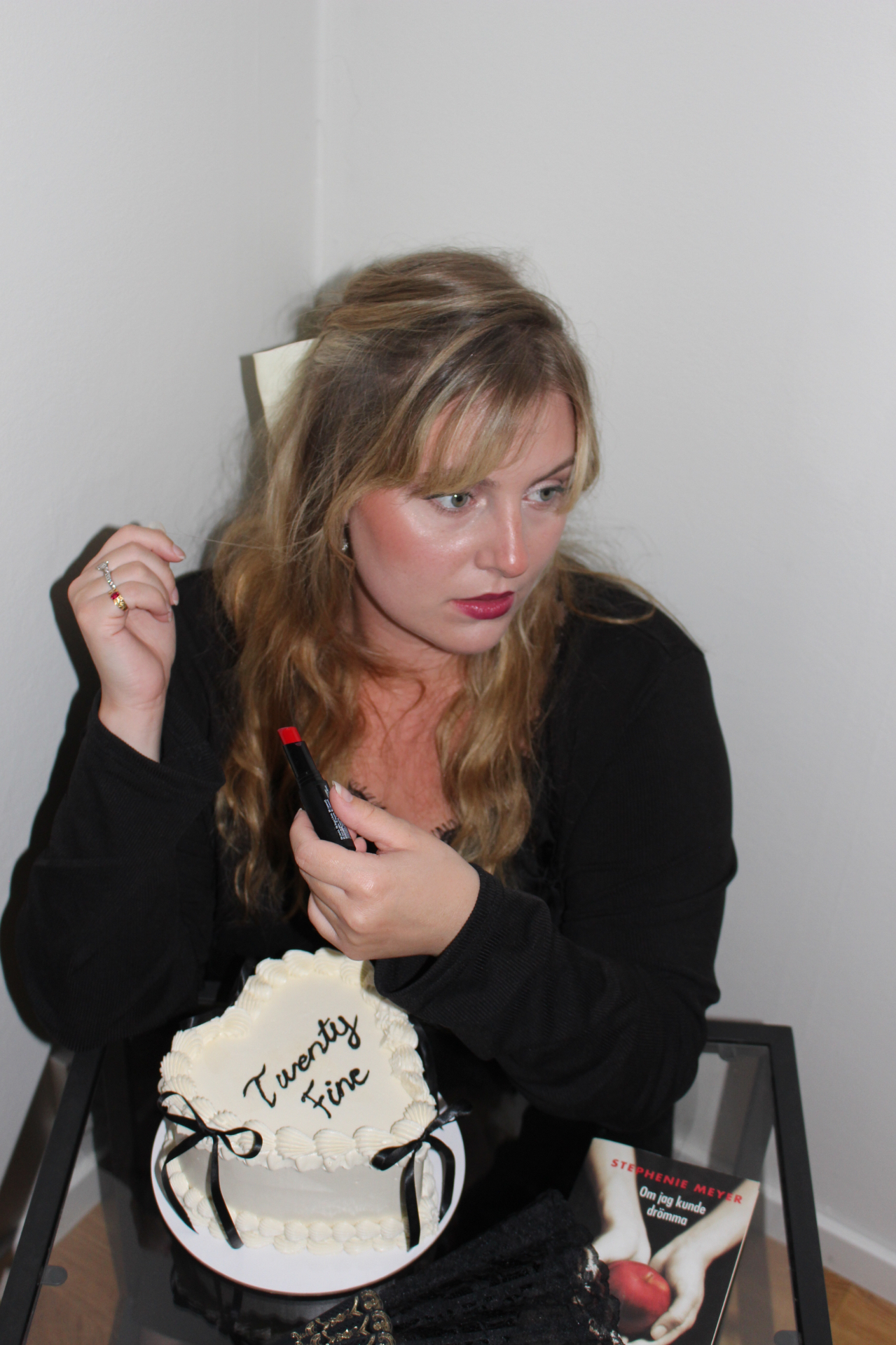 Woman with a birthday cake, red lipstick and a novel